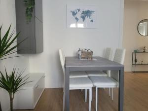 米兰Claro Apartments - Prampolini 12的餐桌、白色椅子和桌子