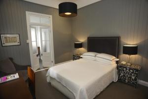 布里斯班希尔之家旅馆的一间卧室配有一张床、两盏灯和一个窗户。