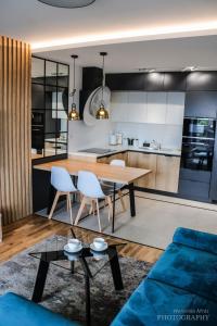 比亚韦斯托克D Apartments Centrum Prowiantowa II的厨房以及带桌椅的起居室。