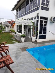 关丹Beit Azzahra Private Pool Villa at Pantai Batu Hitam的一座房子前面设有游泳池