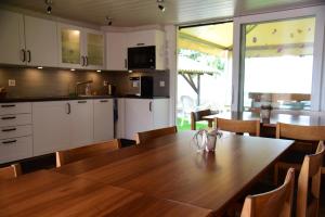 Lengwil沙曼酒店的厨房以及带木桌的用餐室。