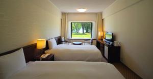 小坂十和田王子酒店的酒店客房设有两张床和窗户。