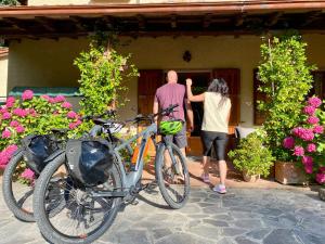普拉托韦基奥大罗纳德片德帕帕酒店的一名男子和一名女子,坐在房子外,骑着自行车
