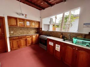 阿约拉港维斯塔马尔旅舍的厨房配有木制橱柜和窗户。