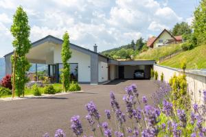 德意志兰茨贝格Greim15 --- ganzes Ferienhaus mit Fernsicht, Pool, Wellness的紫色花的山丘上的房子