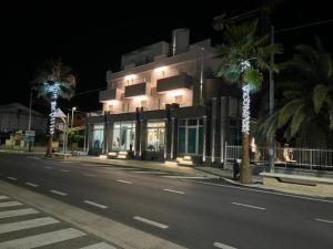 阿尔巴·阿德里亚蒂卡Hotel Alb's的街道边有棕榈树的建筑
