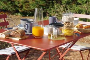 布尔圣昂代奥Le Grand Cèdre - 2 Chambres d'hôtes - Sud Ardèche的一张野餐桌,包括食物、橙汁和面包