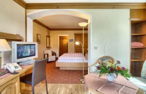 柯尼希斯湖畔舍瑙盖瑞根霍夫酒店的一间带书桌的客厅和一间卧室