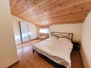 第比利斯Homelike B&B的一间卧室设有一张带木制天花板的大床