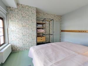 苏希采Baron Apartments Sušice的一间卧室配有一张床和一张带花卉壁纸的墙壁
