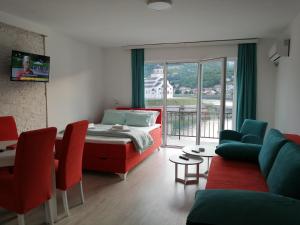 维舍格勒Vila Leolaz的一间卧室配有一张床,客厅配有红色椅子