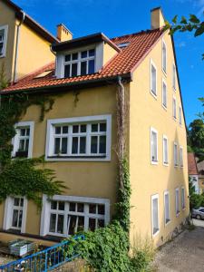 斯雷布纳古拉Apartament w Starej Szkole的黄色的房屋,有红色的屋顶