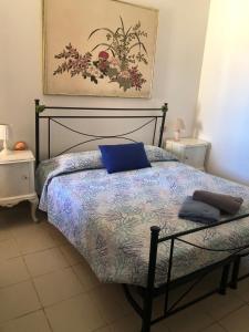 托雷戴科尔萨里Aria Dorata的一间卧室配有一张带蓝色枕头的床。