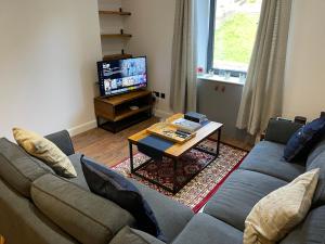 加拉希尔斯Renovated apartment, Galashiels A7的带沙发、桌子和电视的客厅