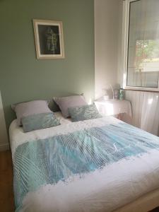 马雷讷Chambre Zen à la campagne的一间卧室配有一张大床和两个枕头