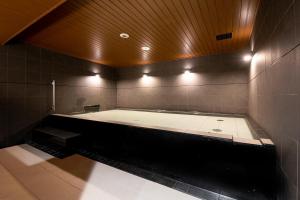 东京First Cabin Ichigaya的大浴室设有大浴缸及灯光