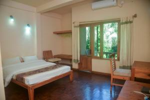 索拉哈奇旺天堂酒店的一间卧室配有一张床、一张书桌和一个窗户。