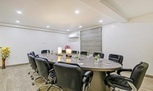 古尔冈Treebo Trend Ahinsa Residency Sohna Road的一间会议室,配有大桌子和椅子