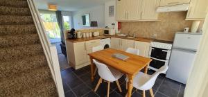 纽基3 Manor Villas Newquay的厨房配有木桌和白色家电