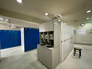 福山カプセル&サウナ日本 -男性専用 men only-的大房间设有蓝色储物柜和凳子