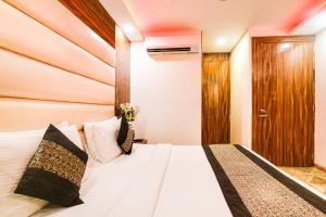 新德里Hotel Olivia Inn At Delhi Airport的卧室配有白色的床和木制床头板