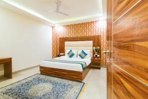 新德里Hotel Olivia Inn At Delhi Airport的一间卧室配有一张床和一扇木门