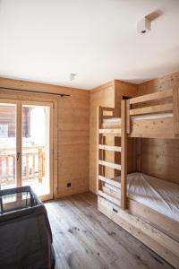 琪纳尔Polaris appartement 2的卧室设有木墙和一张双层床。