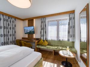 菲根Hotel Landhaus Zillertal的配有一张床和一张书桌的酒店客房