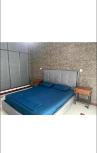 伊夫兰Bel appartement à Ifrane的一间卧室配有一张蓝色的床和一张桌子