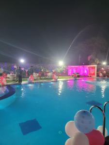 穆扎夫法尔普尔Blue Diamond Resort & Hotel的游泳池在晚上设有喷泉