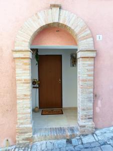 雷卡纳蒂La Casa di LEO - Apartments的通往粉色建筑门的拱门