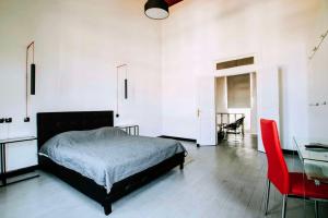伊古迈尼察The Pitoulis Mansion的一间卧室配有一张床、一张桌子和一把红色椅子