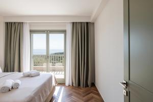 阿斯特里斯Helia All Seasons Apartments的酒店客房设有一张床和一个大窗户