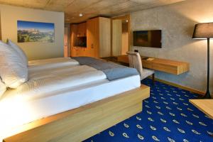 奈福尔斯City Hotel Glarnerland的配有一张床和一张书桌的酒店客房