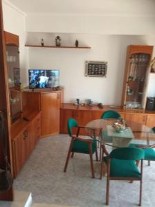 VilajuigaCASA LA SABONERA的客厅配有桌椅和电视。