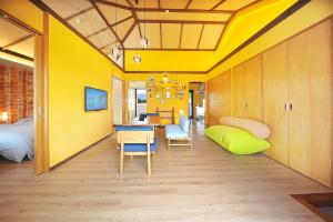 名户SUMUVILLA - Vacation STAY 84924v的客房拥有黄色的墙壁和桌椅。