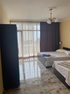 卡瓦拉提Badu Guest House的一间卧室设有两张床和大窗户