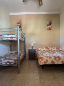 卢克Casa Rural El Cuco的一间卧室设有两张双层床和床头柜。