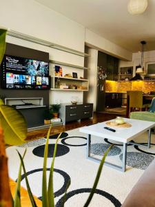 普里什蒂纳My Home in Prishtina - Spacious & Cozy 2BR Apartment with Balcony的客厅配有白色桌子和电视