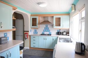 班戈Near Sea House Stay的厨房配有蓝色橱柜和水槽