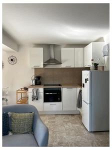 博尼法乔Appartement duplex plein sud sur le port de Bonifacio的厨房配有白色橱柜和冰箱。