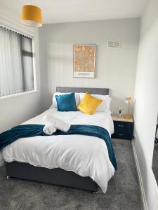 唐克斯特HILLTOP PLACE Suites Near Doncaster RaceCourse的一间卧室配有一张带蓝色和黄色枕头的大床