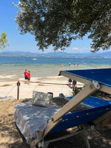 西尔米奥奈Hotel Casa Scaligeri的海滩上的蓝色床,人们在水中