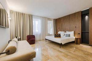 西尔米奥奈Hotel Casa Scaligeri的酒店客房,设有两张床和一张沙发