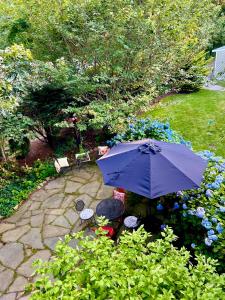 法尔茅斯Frederick William House的一个带遮阳伞、椅子和鲜花的庭院