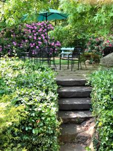 法尔茅斯Frederick William House的花园内带椅子和遮阳伞的石道