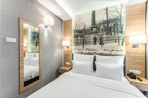 卢布林维尼亚夫斯基酒店的酒店客房设有一张床,并展示了艾菲尔铁塔的画面