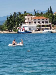 奥米沙利Villa Riva的水体上的两个男人