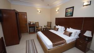 卡拉奇World Inn Karachi的一间卧室配有一张大床和木制床头板