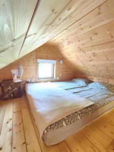 KärdeSelf Check-in Sauna Cabin next to Hiking Trails的小木屋内的一张床位,设有窗户